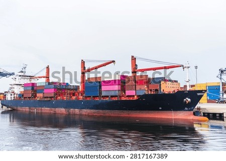 Container ship berthed alongside a container terminal during cargo operations.