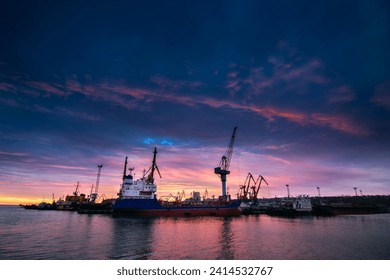 Container ship docked at industrial port. Sunset silhouettes cranes, vessel ready for global trade. Maritime cargo transport, logistics. Shipping freight, harbor facilities, nautical export import. - Powered by Shutterstock