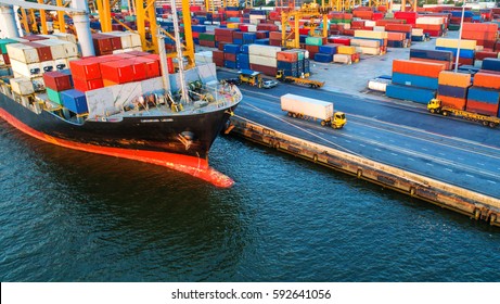 Container ship in export and import business and logistics. Shipping cargo to harbor by crane. Water transport International. Aerial view