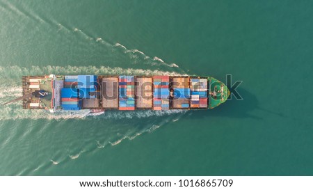 Container ship in export and import business and logistics. Shipping cargo to harbor by crane. Water transport International. Aerial view