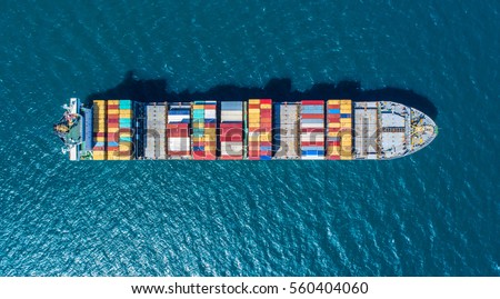 Container ship in export and import business and logistics. Shipping cargo to harbor by crane. Water transport International. Aerial view
