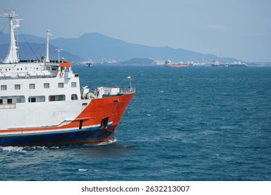Container Ship Navigating Through Calm Ocean Waters Near Coastal Mountains