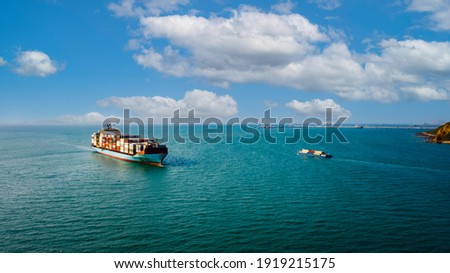 Container ship transporting cargo logistic to import export goods internationally around the world, including Asia Pacific and Europe, by deep sea blue sky background Aerial view photograph from drone