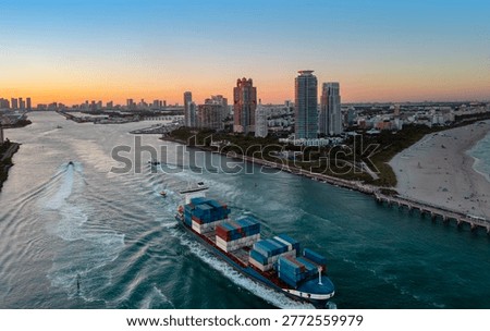 Container ship transporting cargo on Miami Beach. Cargo vessel with stacked shipping containers. Global trade concept with cargo. Container ship sailing. Drone view of cargo shipping vessel.