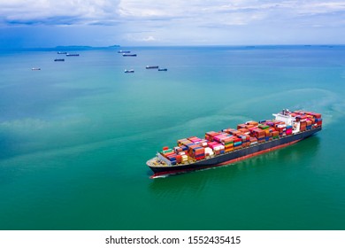 Container Ship Transporting Large Cargo To Import And Export Goods Internationally Around The World, Including Asia Pacific And Europe, By Sea Blue Sky Background Aerial View From Drone Photograph
