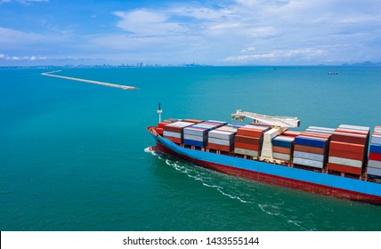 Container Ships Transporting Large Cargo To Import And Export Goods Internationally Around The World, Including Asia Pacific And Europe, By Green Sea Blue Sky Aerial View With Drone Camera Photography