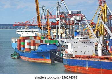 Container Stack And Cargo Ship Under Crane Bridge