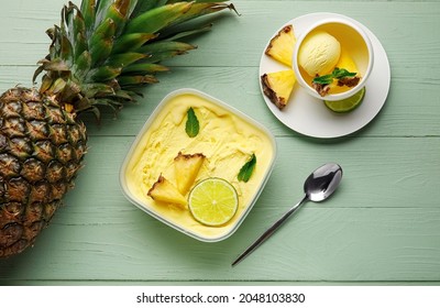 Container with tasty pineapple ice cream on color wooden background - Powered by Shutterstock