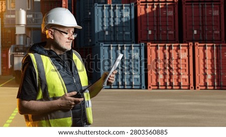 Container terminal, logistics supervisor checks cargo documents and radio communication near shipping containers at industrial freight yard