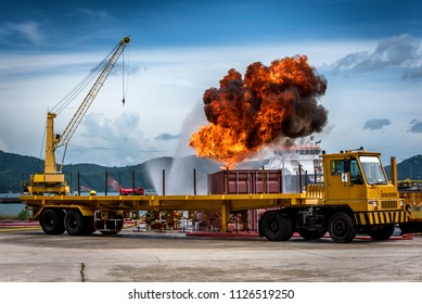 Container Truck Crash Accident On The Road In The Port And Fire Burning Up. Fire Flame In An Emergency Situation. Fireman Using Water And Extinguisher To Fighting With Fire Flame