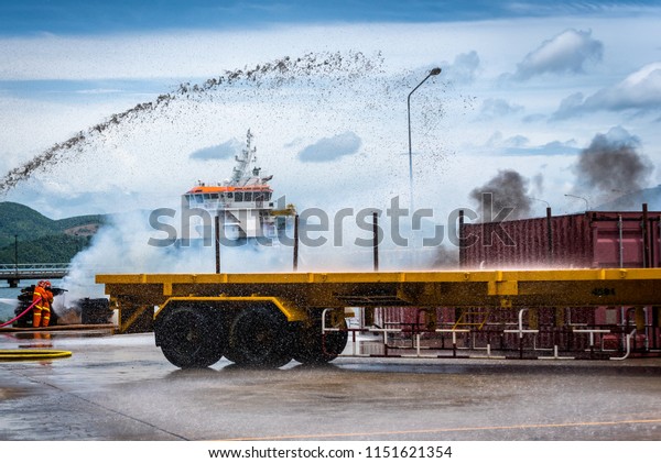 Container Truck\
crash accident on the road in the port and fire burning up. fire\
flame in an emergency situation. Fireman using water and\
extinguisher to fighting with fire\
flame