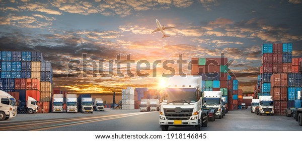 Container truck in ship port for business Logistics and\
transportation of Container Cargo ship and Cargo plane with working\
crane bridge in shipyard, logistic import export and transport\
industry 