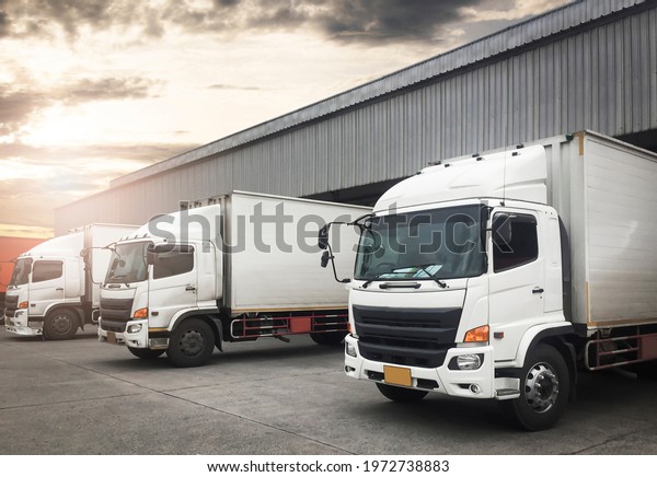 Container Trucks Parked Loading at Dock Warehouse.\
Shipping Warehouse Logistics.Cargo Shipment.  Industry Freight\
Truck Transportation.\
\
