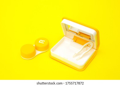 Container And Tweezers For Contact Lenses And An Open Case With A Mirror For Storing Them Yakro Yellow On A Yellow Background