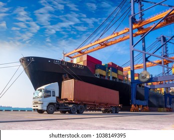 The container vessel  during discharging at an industrial port and move containers to container yard by trucks.