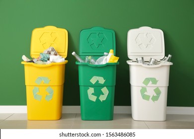 Containers with different types of garbage near color wall. Recycling concept - Shutterstock ID 1563486085