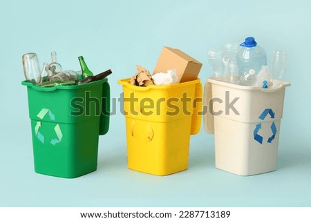Containers with different types of garbage on light blue background. Recycling concept