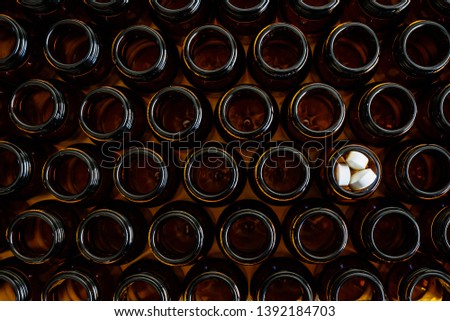 Containers for empty medicines except one full of pills, disease and medicines concept.