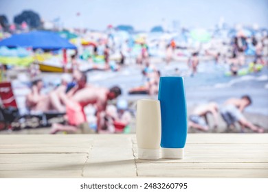 Containers for sun tan lotion and sunscreen oils on a bright table with a crowded beach and a sea and clear sky background. - Powered by Shutterstock