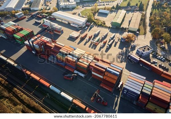 Containers warehouse on\
platform with cranes and forklifts, aerial view. Business and\
logistic concept, cargo transit. Katy Wroclawskie, Poland - October\
29, 2021