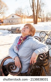 Contemplative Casual Mature Woman   Sitting On Bench In Spring Park