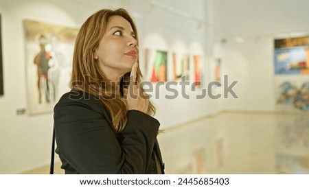 A contemplative hispanic woman admires artwork in a bright museum gallery interior.