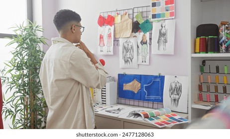 A contemplative man in a tailor shop surrounded by fashion sketches and colorful thread spools. - Powered by Shutterstock