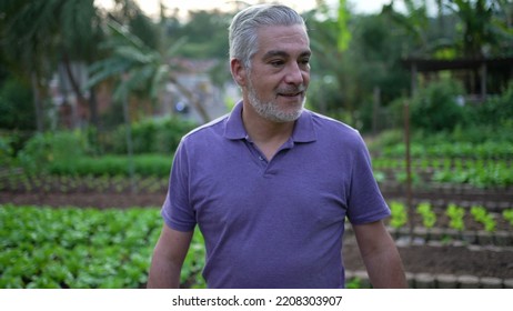 Contemplative Senior Man Walking Outdoors In Small Farm. Pensive Older Person Walks Forward Portrait Face Closeup