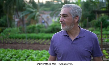 Contemplative Senior Man Walking Outdoors In Small Farm. Pensive Older Person Walks Forward Portrait Face Closeup