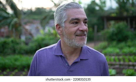 Contemplative Senior Man Walking Outdoors In Small Farm. Pensive Older Person Walks Forward Portrait Face Closeup