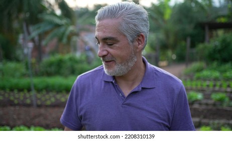 Contemplative Senior Man Walking Outdoors In Small Farm. Pensive Older Person Walks Forward Portrait Face Closeup