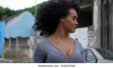 A Contemplative Young Latina Woman Walking Outside In Urban Street