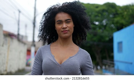 A Contemplative Young Latina Woman Walking Outside In Urban Street