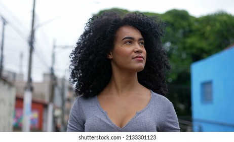 A Contemplative Young Latina Woman Walking Outside In Urban Street