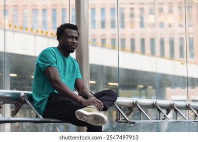 Contemplative young man waiting at a contemporary urban bus stop for public transportation - Powered by Shutterstock