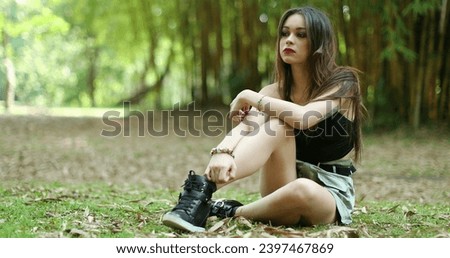 Contemplative young woman sitted in outdoor park thinking. Thoughtful girl in 20s thinking