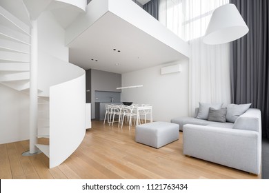 Contemporary apartment with white, spiral staircase and large sofa - Powered by Shutterstock