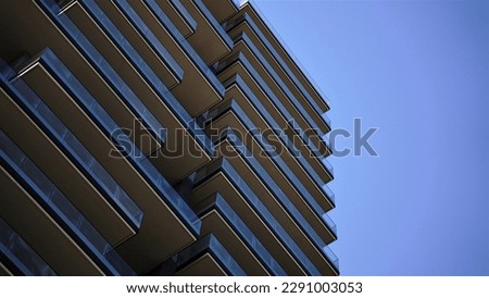 contemporary building facade with balconies against blue sky