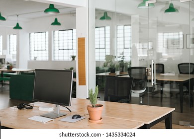 Contemporary business interior containing tables and chairs, computers and office supplies before the workday has started - Shutterstock ID 1435334024