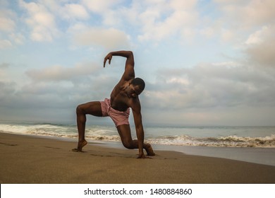 Contemporary Dance Choreographer And Dancer Doing Ballet Beach Workout . A Young Attractive And Athletic Black African American Man Dancing On Sunrise Doing Dramatic Performance 