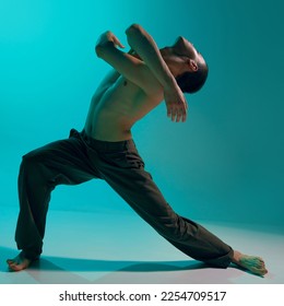 Contemporary dance style. Freedom. Young flexible man dancing over blue studio background. Expressing feelings through movements. Concept of art, body aesthetics, motion, action, inspiration. - Shutterstock ID 2254709517