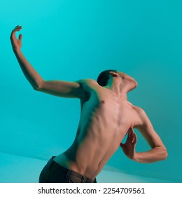 Contemporary dance style. Young shirtless, flexible man dancing over blue, cyan studio background. Expressing feelings through movements. Concept of art, body aesthetics, motion, action, inspiration. - Shutterstock ID 2254709561