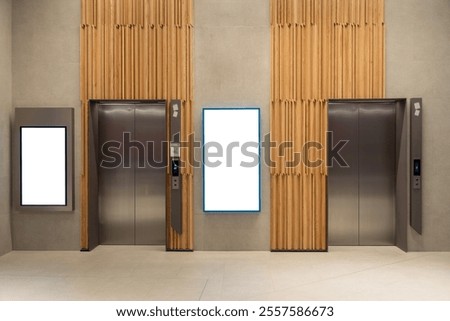 Contemporary elevator lobby featuring two modern elevators with polished metal doors on corridor lobby, mockup billboard with frame between elevators, blank space for advertisement or announcement