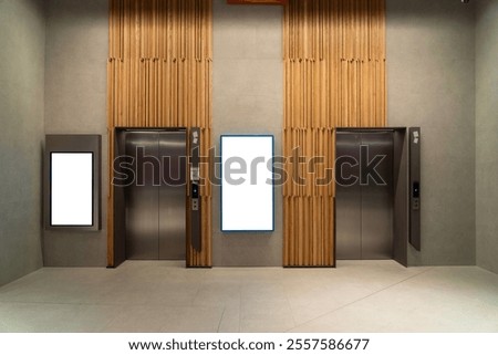 Contemporary elevator lobby featuring two modern elevators with polished metal doors on corridor lobby, mockup billboard with frame between elevators, blank space for advertisement or announcement