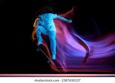 Contemporary extreme kind of sport. Man, skateboarder performing tricks with mixed neon motion blur isolated black background. Concept of youth culture, active lifestyle, style and fashion, art. - Powered by Shutterstock