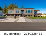 Contemporary home exterior with dark blue sky stamped concrete driveway brown house and expansive deck