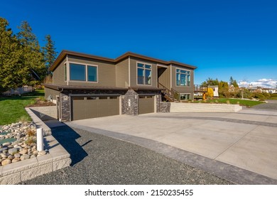 Contemporary Home Exterior With Dark Blue Sky Stamped Concrete Driveway Brown House And Expansive Deck