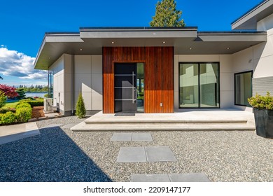 Contemporary Home Exterior On Lakeshore With Flat Roof And Large Feature Windows