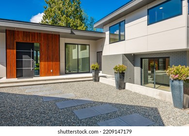 Contemporary Home Exterior On Lakeshore With Flat Roof And Large Feature Windows