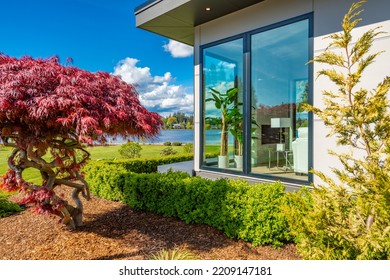 Contemporary Home Exterior On Lakeshore With Flat Roof And Large Feature Windows